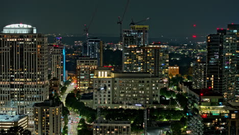 Atlanta-Georgia-Aerial-v900-hyperlapse-drone-Piedmont-Park,-tracking-shot-of-Midtown-urban-night-cityscape-with-illuminated-streets-and-high-rise-buildings---Shot-with-Mavic-3-Pro-Cine---July-2023