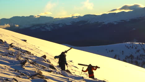 Filmisches-Epos-Ikone-Vail-Pass-Colorado-Goldene-Stunde-Sonnenuntergang-Vater-Sohn-Skifahrer-Wandern-über-Felsen-Mit-Skiern-Auf-Schultern-über-Der-Baumgrenze-Pulverschnee-Episch-Felsige-Berglandschaft-Szenisches-Hinterland-Folgen-Schwenk