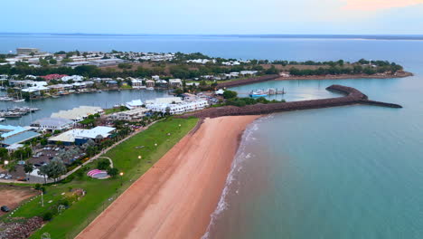 Sunset-drone-aerial-footage-of-a-small-bay-in-a-coastal-town