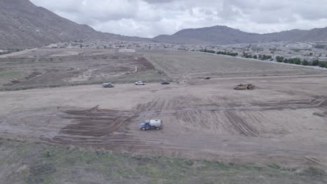 A-drone-captures-the-scene-as-a-water-truck-restarts-its-rotation-as-it-completes-methodically-dumping-water-to-prepare-a-new-lot-for-future-home-construction