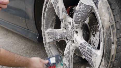Cleaning-a-silver-wheel-on-a-black-car