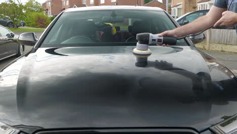 Polishing-a-black-car-bonnet-hood-with-a-machine-polisher
