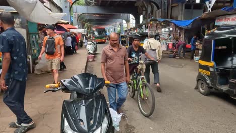 Mumbai,-Indien---20.-August-2023:-Eine-Belebte-Durchgangsstraße-Mit-Menschen-Und-Verschiedenen-Fahrzeugtypen-Auf-Einem-Markt-In-Mumbai,-Indien