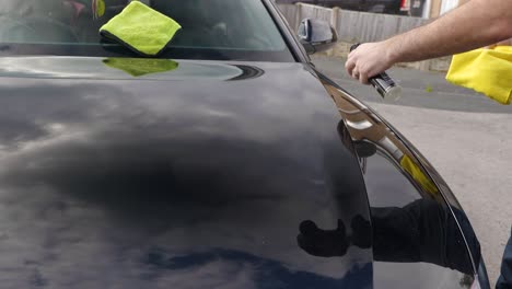 Applying-a-spray-sealant-to-a-black-car-bonnet-hood