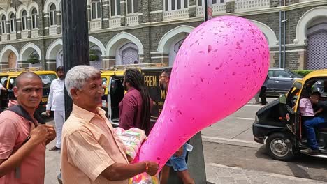 Mumbai,-Indien---20.-August-2023:-Ein-Freundlicher-Ballonverkäufer-In-Mumbai,-Indien,-Vor-Dem-Taj-Palace-Und-Dem-Taj-Mahal-Tower