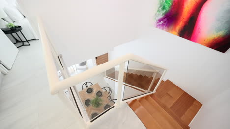 Moderne-Treppe-Mit-Blick-Auf-Den-Esstisch-Mit-Kronleuchter-Und-Farbenfrohen-Modernen-Kunstwerken