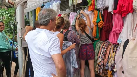 Mumbai,-India---20-August-2023:-Tourists-looking-through-clothes-for-sale-at-a-market-in-Mumbai-near-the-Gateway-of-India