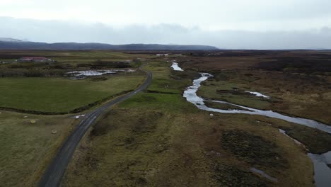 Road-and-river-in-the-West-side-of-Iceland-on-a-cloudy-morning,-aerial