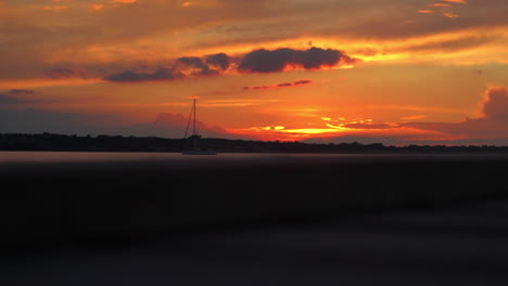 Timelapse-of-a-sailboat-during-a-vibrant-sunset