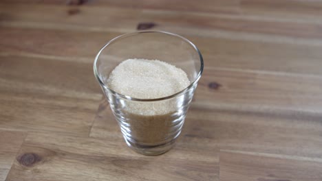 Panning-shot-of-brown-sugar-sitting-in-a-jar