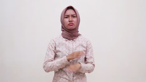 Young-asian-muslim-girl-standing-while-crossing-her-hands-showing-rejection-and-covering-her-ears
