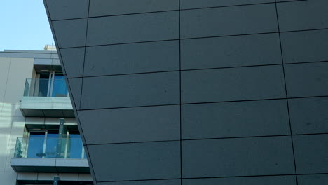 Architekturdetail-Einer-Modernen-Gebäudeecke-Mit-Glasbalustraden-Und-Einer-Granitfassade