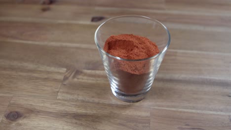 Panning-shot-of-dried-paprika-powder-sitting-in-a-jar