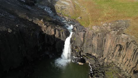 Unknown-waterfall-in-the-depths-of-South-Iceland-on-a-sunny-autumn-morning,-aerial