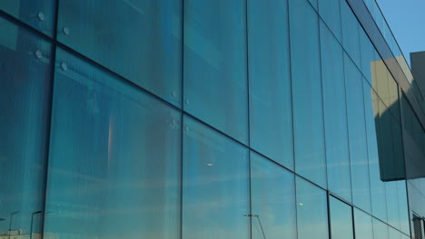 Cielo-Azul-Reflejado-En-Los-Grandes-Paneles-De-Vidrio-De-La-Pared-Exterior-De-Un-Edificio-Moderno.