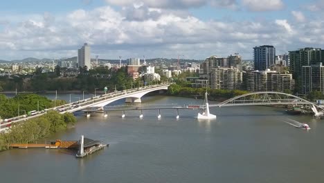 Cars-drive-along-bridge-intersecting-with-pier-and-pedestrian-bridge-in-Brisbane