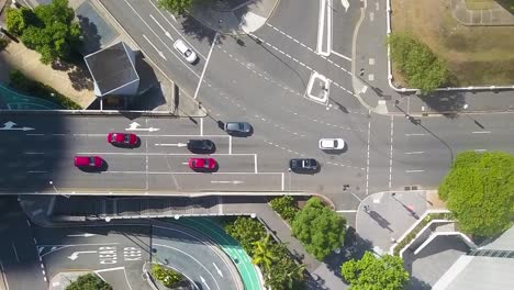 Drone-top-down-left-to-right-pan-across-cars-driving-along-street-in-multi-level-roadway