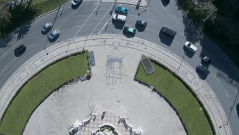 Traffic-jam-at-a-roundabout,-cars-driving-around,-aerial-rotation-view-in-Lisbon,-Portugal
