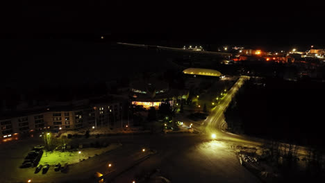 Aerial-view-away-from-the-Tropiclandia-water-park-and-resort,-night-in-Vaasa,-Finland