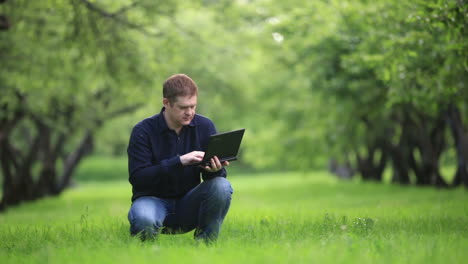 Man-working-with-notebook-in-the-park