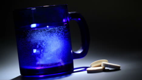 Tablet-dissolving-in-a-blue-glass-of-water