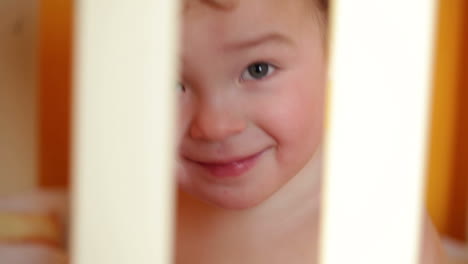 Portrait-of-the-smiling-little-boy-in-the-playpen