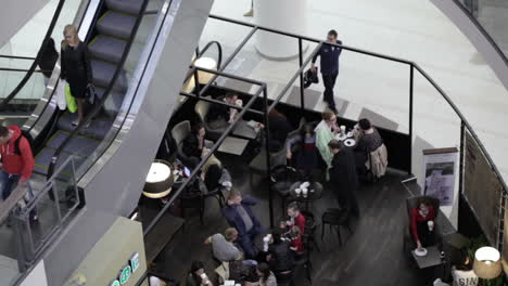 Die-Leute-Essen-Im-Café-Und-Fahren-Auf-Der-Rolltreppe-Auf-Und-Ab