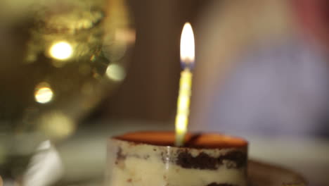 Glass-of-champagne-and-candle-in-the-tiramisu-cake