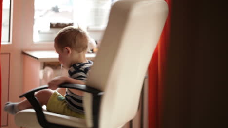 Zweijähriger-Junge-Dreht-Sich-Auf-Einem-Stuhl