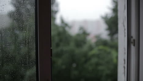 Heavy-rain-Focus-pulling-from-window-to-the-building