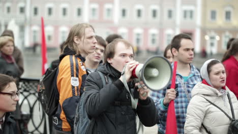 Junger-Mann-Schreit-Mit-Einem-Megaphon-Auf-Die-Protestkundgebung
