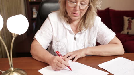 Middle-aged-woman-writing-at-the-table