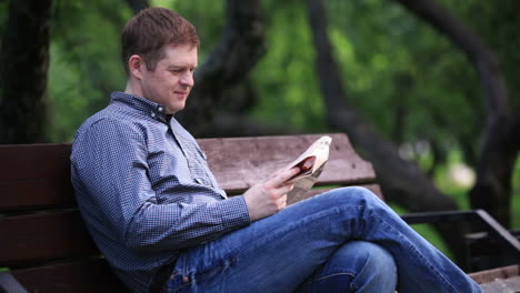Man-reads-newspaper-on-bench-in-the-park-2