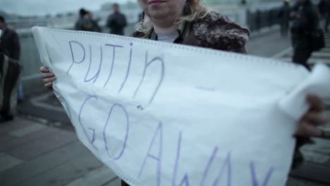 Woman-holds-a-placard-Putin-Go-Away