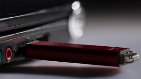 Einfügen-Eines-Roten-USB-Flash-Laufwerks-In-Die-Makroaufnahme-Eines-Notebooks