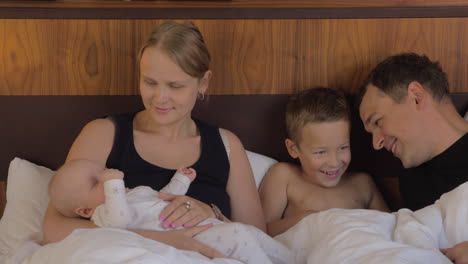 Family-of-four-together-in-bed-at-home