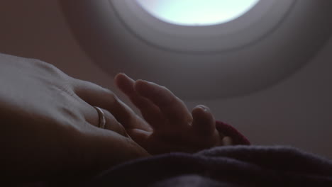 Mother-and-baby-hands-view-in-airplane