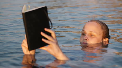 Woman-reading-while-floating-in-the-sea
