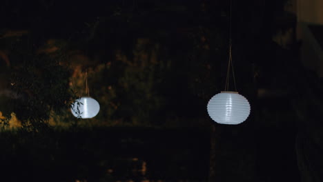 Round-white-paper-lanterns-in-night-garden