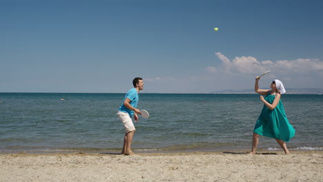 Couple-playing-bat-and-ball-at-the-beach