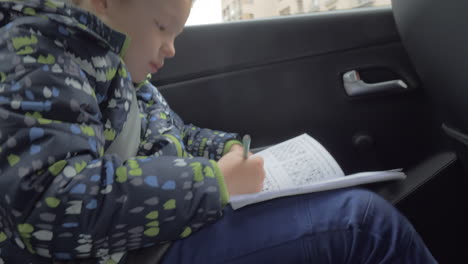 Child-solving-chess-puzzles-in-the-car