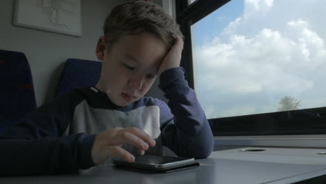 Kid-playing-on-cell-when-traveling-by-train