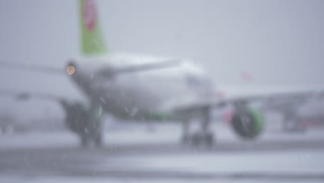 Blur-of-airplane-driving-on-the-landing-strip-view-in-snowfall