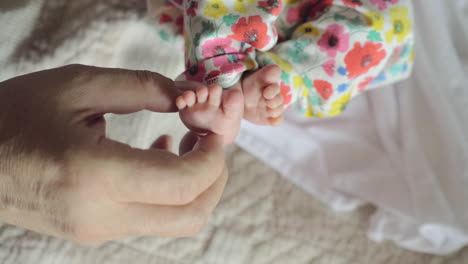 Grandfather-touching-feet-of-newborn-baby