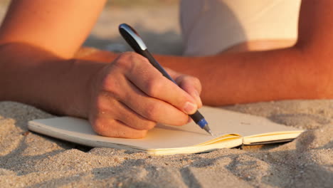 Man-writing-in-his-diary-at-the-beach