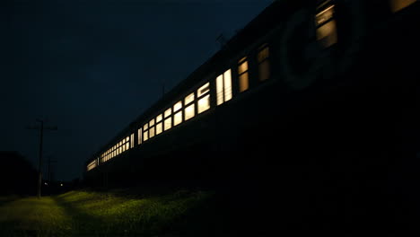 Train-passing-fast-through-a-rural-area-by-night