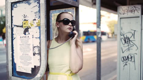 Woman-chatting-on-a-public-telephone