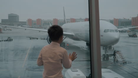 Kind-Schaut-Durch-Das-Fenster-Auf-Das-Flugzeug