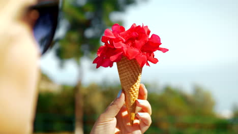 Woman-holding-red-flowers-in-waffle-cone