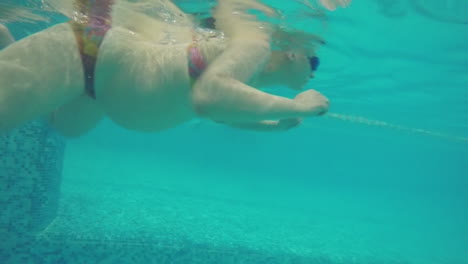 Unterwasseransicht-Einer-Schwangeren-Frau,-Die-Im-Pool-Schwimmt